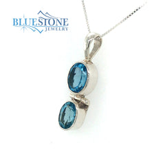 Sterling Silver Rhodium Plated Pendant with Two Oval Cut Blue Topazes.