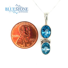 Sterling Silver Rhodium Plated Pendant with Two Oval Cut Blue Topazes.